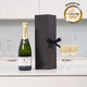 Personalised Champagne: A bottle of champagne is placed next to two filled flutes on a white countertop. The bottle is in a sleek black gift box tied with a ribbon. Subtle decorative elements are visible in the background. Personalised Champagne: A bottle of champagne is placed next to two filled flutes on a white countertop. The bottle is in a sleek black gift box tied with a ribbon. Subtle decorative elements are visible in the background.